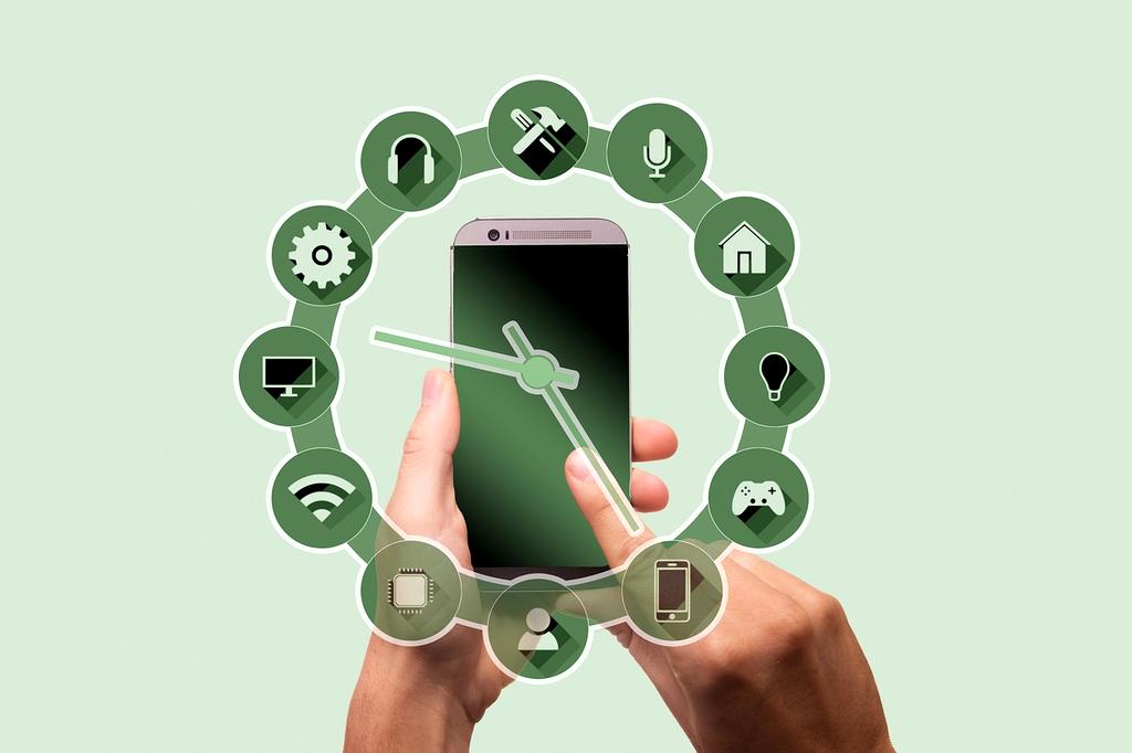 Hands typing on laptop near wireless router and smartphone